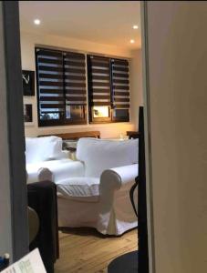 1 dormitorio con 2 camas con sábanas blancas y ventana en Villa avec piscine, terrasse, jardin et vue…, en Bort-les-Orgues