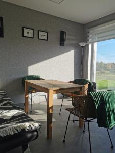 的住宿－''Ābeļdārza māja''，一间带木桌和椅子的用餐室