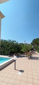 une terrasse avec une piscine à côté d'une maison dans l'établissement Villetta Guardiano del faro con piscina, à Leuca