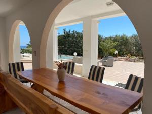 - une salle à manger avec une table et des chaises en bois dans l'établissement Villetta Guardiano del faro con piscina, à Leuca