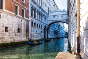 eine Brücke über einen Kanal mit Gondeln im Wasser in der Unterkunft Kya Venice and Beach House: Venezia, mare e laguna in Cavallino-Treporti