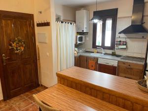 a kitchen with a wooden counter and a wooden door at La casita del pueblo in Fondón