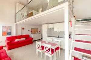ein Wohnzimmer mit einem roten Sofa und einem Tisch in der Unterkunft Al Campanile Madonna dell'Orto in Venedig