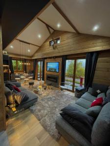 ein großes Wohnzimmer mit Sofas und einem TV in der Unterkunft CHALET MONT BLANC in Combloux