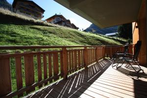 une terrasse en bois avec un banc sur une colline dans l'établissement Châtel - Appartement 4-6 personnes - Les Châlets des Freinets C203, à Châtel