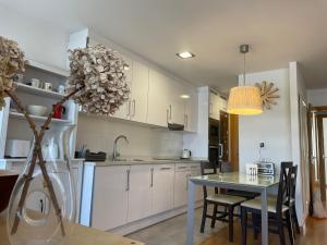 a kitchen with a table and a dining room at El rincón de Poniente in Gijón