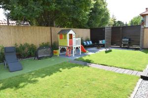 a small backyard with a play yard with a playground at Bell Nyaraló Agárd in Gárdony
