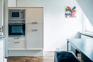 eine Küche mit einem weißen Kühlschrank und einer Mikrowelle in der Unterkunft Fördeblick in Flensburg