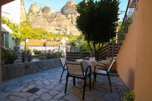 a table and chairs with a mountain in the background at The house under the rocks of Meteora 2 in Kalabaka
