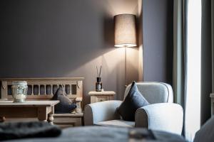 a living room with two chairs and a table and a lamp at Hotel Acadia - Adults Mountain Home in Selva di Val Gardena