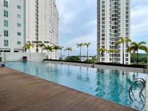 a swimming pool in the middle of two tall buildings at Pool View Stylish Suite at Jelutong Penang 1-4pax in George Town
