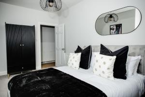 um quarto com uma cama grande e almofadas pretas e brancas em Crieff House em Crieff