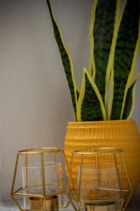 a yellow vase with a plant and two candle holders at Crieff House in Crieff