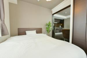una camera da letto con un grande letto bianco e uno specchio di SUNCORT Minami 6-jo II a Sapporo
