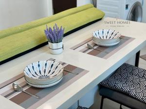 a table with two bowls and spoons on it at Pool View Stylish Suite at Jelutong Penang 1-4pax in George Town