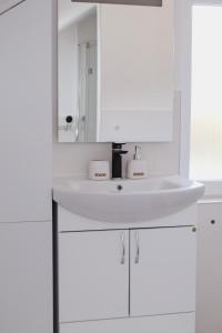 a white bathroom with a sink and a mirror at My sweet home Vrhpraca Jahorina in Jahorina