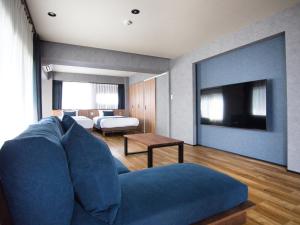sala de estar con sofá azul y TV en ulu Tokyo en Tokio