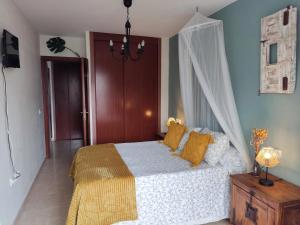 1 dormitorio con cama blanca y almohadas amarillas en LA PITA- Terraza con vistas al mar & parking, a 1 min de la playa en Carboneras
