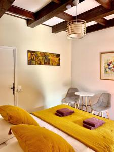 2 camas en una habitación con mesa y sillas en Le Barry du Grand Chemin, en Le Caylar