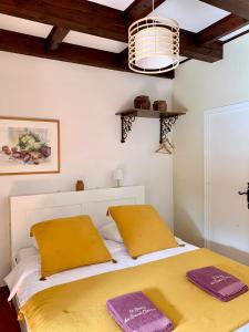een slaapkamer met een bed met gele kussens erop bij Le Barry du Grand Chemin in Le Caylar
