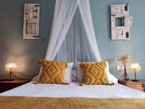 a bedroom with a bed with a white canopy and pillows at LA PITA- Terraza con vistas al mar & parking, a 1 min de la playa in Carboneras