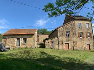 un antiguo edificio de piedra en un campo de césped en Busset Liages situé dans le Bourbonnais 2 chambres lits double et un clic clac, en Busset