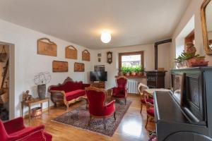 a living room with red chairs and a tv at Hotel Berthod in Courmayeur