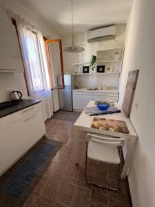 une cuisine avec une table blanche, une table et des chaises dans l'établissement Incantevole mini appartamento in centro a Padova., à Padoue