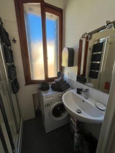 La salle de bains est pourvue d'un lave-linge et d'un lavabo. dans l'établissement Incantevole mini appartamento in centro a Padova., à Padoue