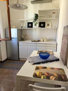 Il comprend une cuisine équipée d'un réfrigérateur et d'une table avec un bol. dans l'établissement Incantevole mini appartamento in centro a Padova., à Padoue