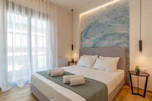 アテネにあるIO SUITESの大きな窓のあるベッドのある寝室