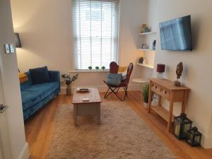 a living room with a blue couch and a table at One Bedroom Flat Central Ipswich in Ipswich