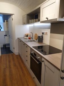 a kitchen with white cabinets and a black stove top oven at One Bedroom Flat Central Ipswich in Ipswich