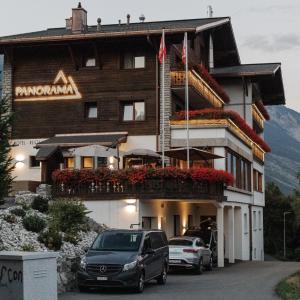 a hotel with cars parked in front of it at Boutique Hotel Panorama in Crans-Montana