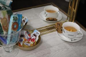 una mesa con dos tazas de té y galletas en Chez Les Sœurs, en Pompeya