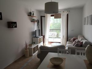 uma sala de estar com um sofá e uma mesa em Apartamento Canela em Ayamonte