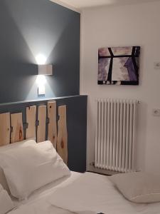 Un dormitorio con una cama blanca y una foto en la pared en Storie di bosco, en Villa Lagarina
