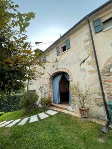 um edifício de tijolos com uma porta e um quintal em La Casa di Laura em Castelcucco