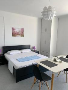 a bedroom with a bed and a desk and a table at TERRACE VIEW APARTMENTS in Sarandë