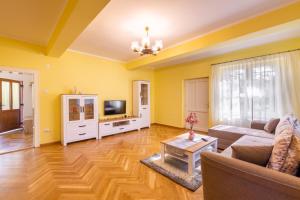 een woonkamer met een bank en een tv bij CASA PANORAMA in Cisnădie