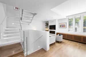 ein Wohnzimmer mit weißen Wänden und einer Treppe in der Unterkunft Solaga - Carmen Beach in Málaga