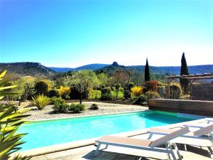 a swimming pool with chairs and a view of the mountains at Roulotte de la Villa Font Vive - Tout équipée, tout confort, situation idéale Sud Ardèche in Grospierres
