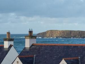 a view of the ocean from the roofs of houses at Harbour View Townhouse in Portrush