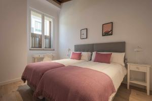 1 dormitorio con 1 cama grande con sábanas rosas y blancas en Los Adelantados El Aljibe Live Canarias, en La Laguna