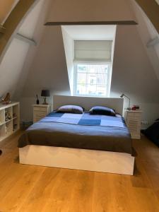 a bedroom with a large bed in an attic at Koetshuis aan het water 3 bedroom villa in Voorburg