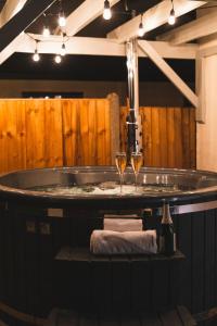 a bath tub with two glasses of wine at Pilgrim Cottage in Tarvin