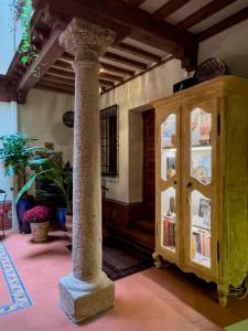 een kamer met een pilaar en een kast met boeken bij Almunia de San Miguel in Toledo