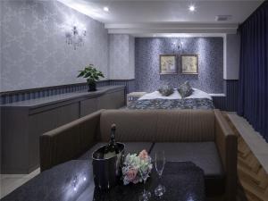 HOTEL xcell في فوكوياما: غرفة نوم بسرير واريكة وطاولة