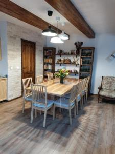 a dining room with a wooden table and chairs at PENSIUNEA DENISIA in Vadu Izei
