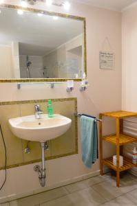 ein Bad mit einem Waschbecken und einem Spiegel in der Unterkunft Ferienwohnung Sesslach Altstadt in Seßlach